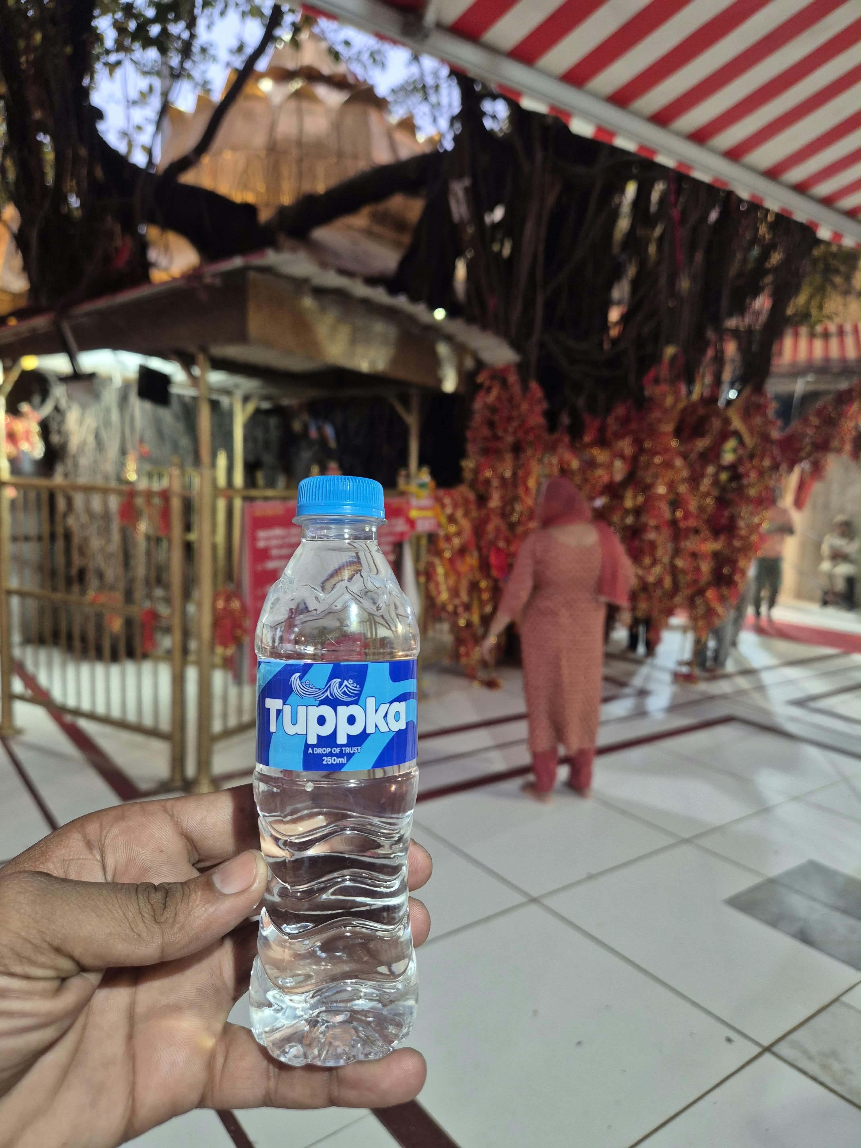 A bottle at the banyan-tree langar corner during the dedication.